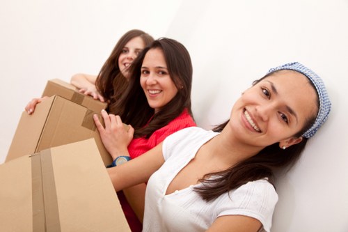 Professional movers carrying items through a Brentford apartment corridor